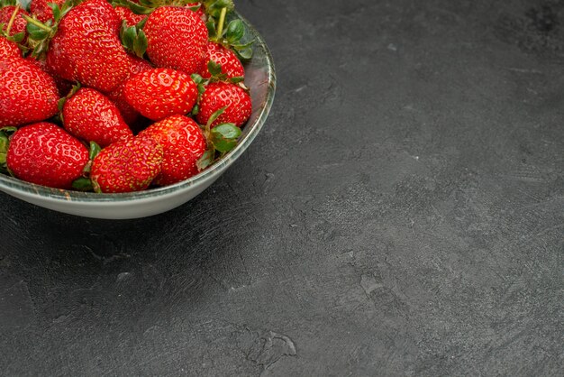 Vue de face fraises rouges fraîches à l'intérieur de la plaque sur fond gris jus d'arbre couleur goût baies été sauvage