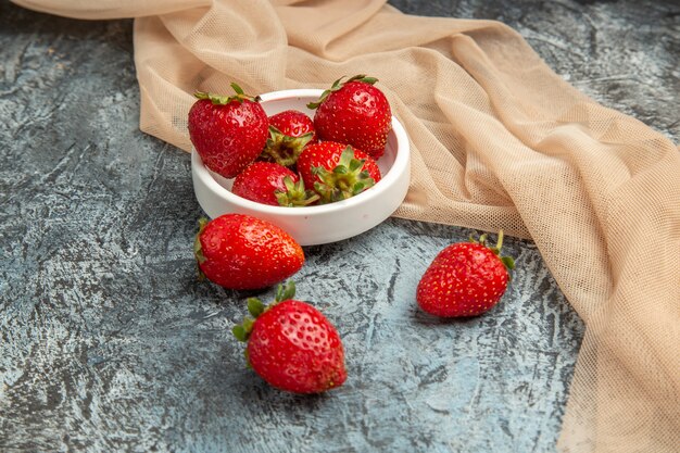 Vue de face fraises rouges fraîches sur la surface sombre-lumière baies de fruits rouges