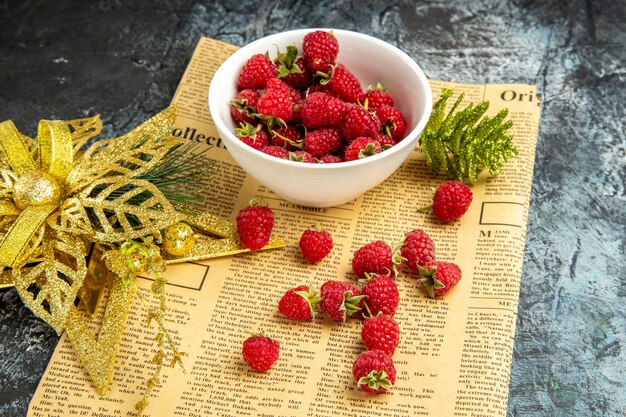 Vue de face de framboises fraîches avec des jouets