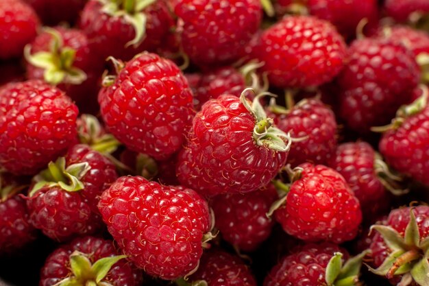 Vue de face de framboises rouges fraîches sur une baie de photo sauvage de canneberge de couleur grise