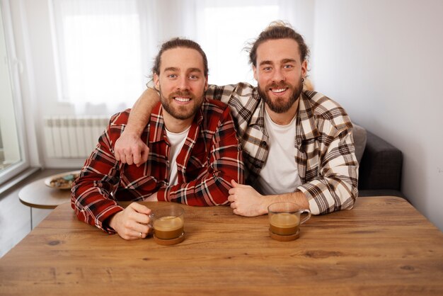 Vue de face frères souriants assis à table