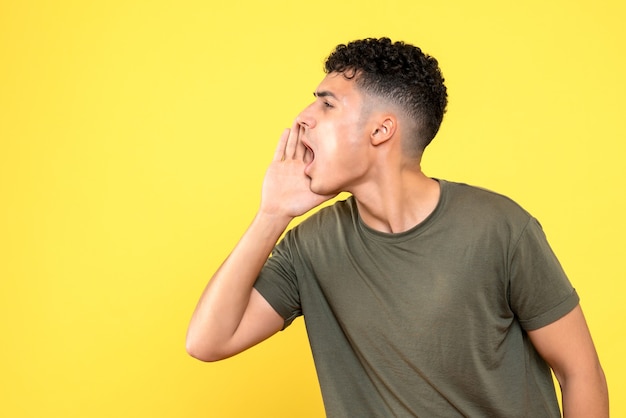 Vue de face un gars le gars hurle et tient une main près de sa bouche