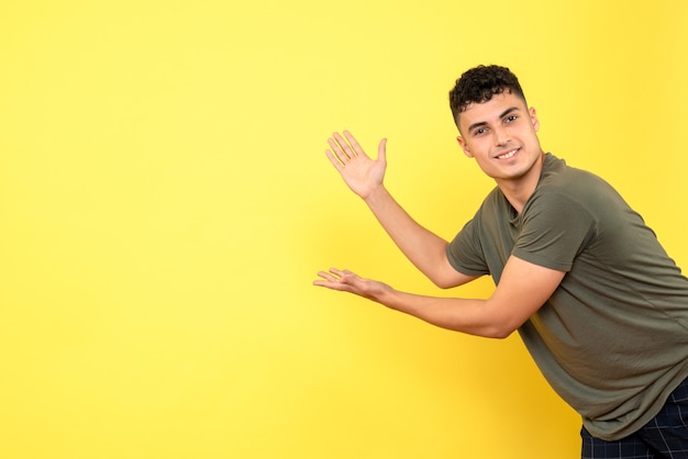 Vue de face un gars le gars souriant pointe vers le mur