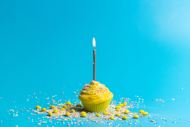 Une vue de face gâteau d'anniversaire jaune avec bougie sur bleu