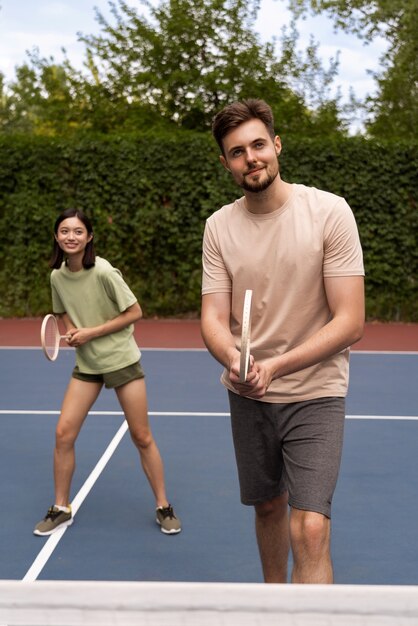 Vue de face des gens jouant au badminton