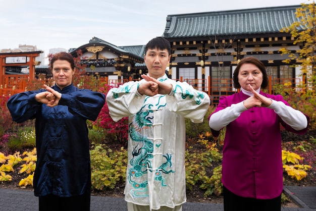 Photo gratuite vue de face des gens pratiquant le tai chi à l'extérieur