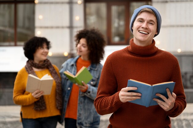 Vue de face des gens souriants tenant des livres