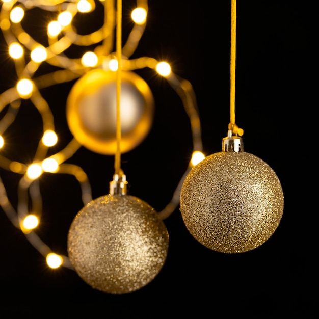 Vue de face des globes de Noël dorés avec des lumières