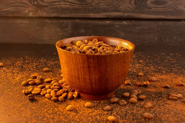 Une vue de face des graines de café brun à l'intérieur de la plaque brune sur la graine de café brun