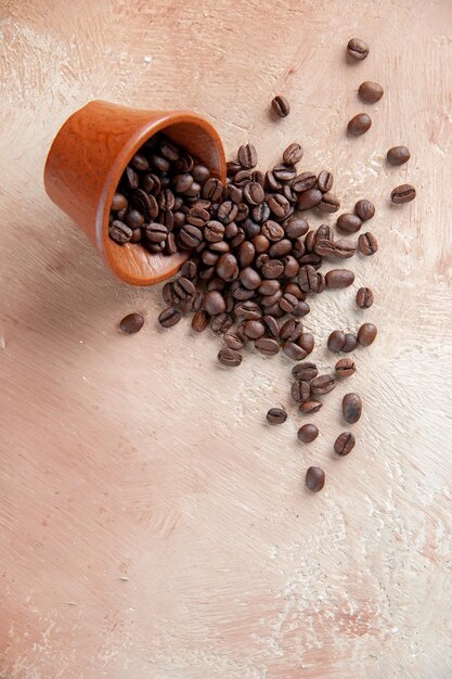 Vue de face des graines de café brunes sur une surface claire boisson mesdames couleur café énergique cacao horizontal