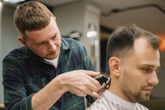 Vue de face de hairstilyst donnant une coupe de cheveux