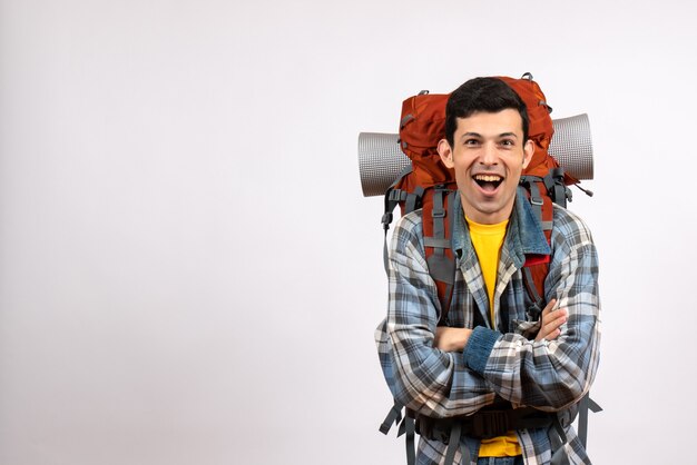 Vue de face heureux jeune voyageur avec sac à dos croisant les mains