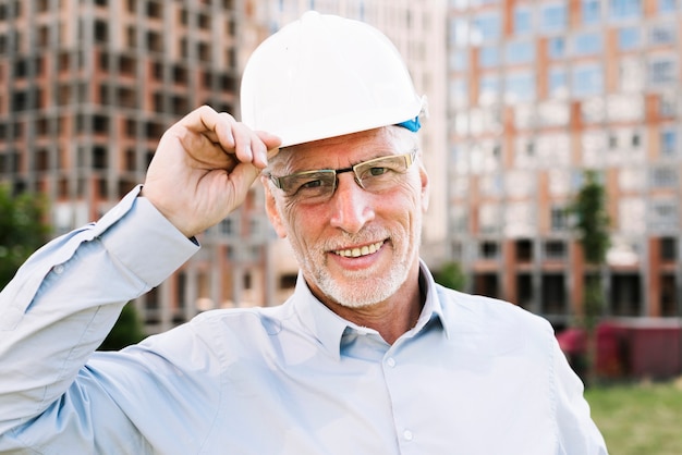 Vue de face heureux vieil homme avec casque blanc