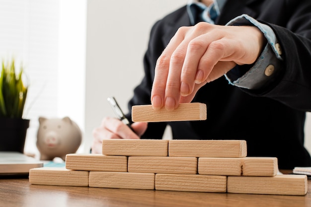 Vue de face de l'homme d'affaires avec des blocs de construction en bois