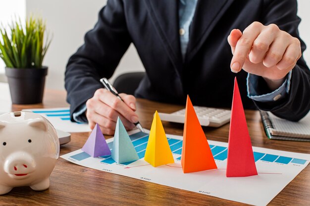 Vue de face de l'homme d'affaires avec des cônes colorés représentant la croissance