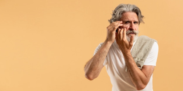 Vue de face de l'homme âgé avec barbe soulignant les rides avec copie espace