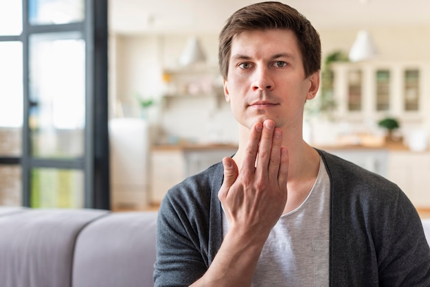 Vue de face de l'homme à l'aide de la langue des signes