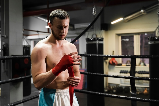 Vue de face homme athlétique de formation en ring de boxe