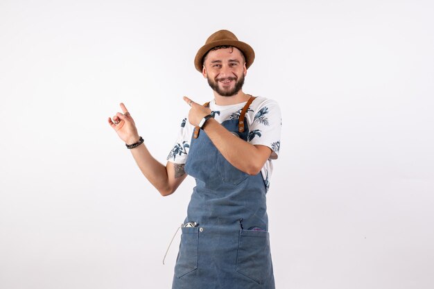 Vue de face homme barman pointant avec le sourire sur le mur blanc bar à alcool club nuit boire modèle de travail