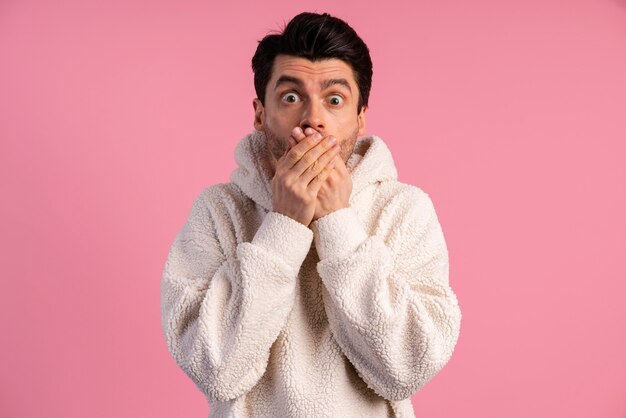 Vue de face de l'homme choqué couvrant sa bouche