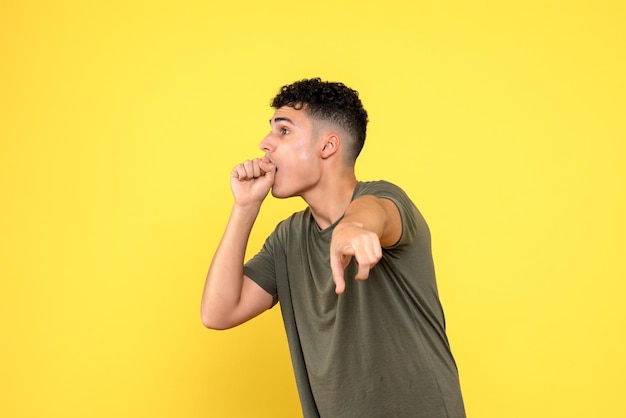 La vue de face de l'homme choqué tient un poing près de sa bouche et pointe vers le côté