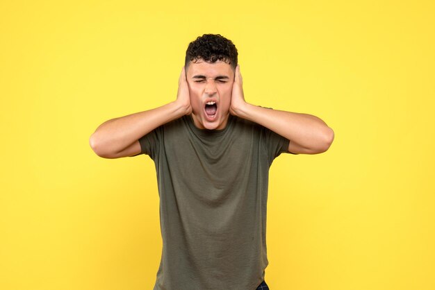 La vue de face de l'homme couvre ses oreilles avec ses mains et crie