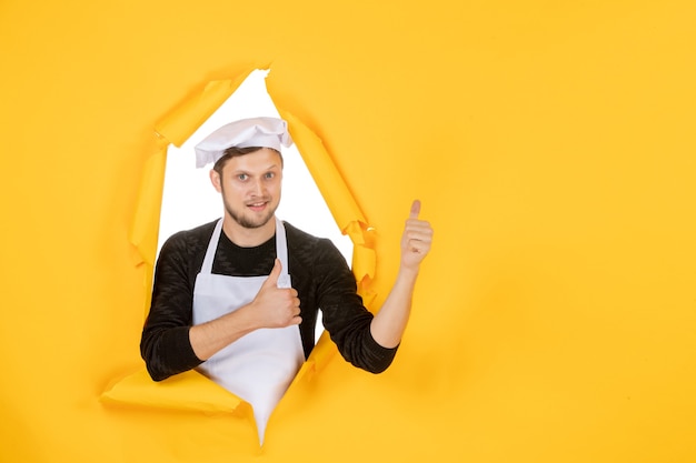 Vue de face homme cuisinier en cape blanche et casquette sur travail déchiré jaune photo couleur nourriture homme cuisine