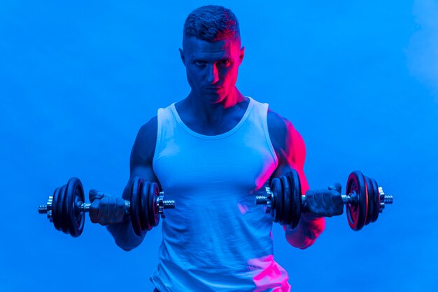 Vue de face de l'homme en débardeur exerçant avec des poids