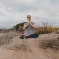 Photo gratuite vue de face de l'homme à l'extérieur se détendre tout en faisant du yoga