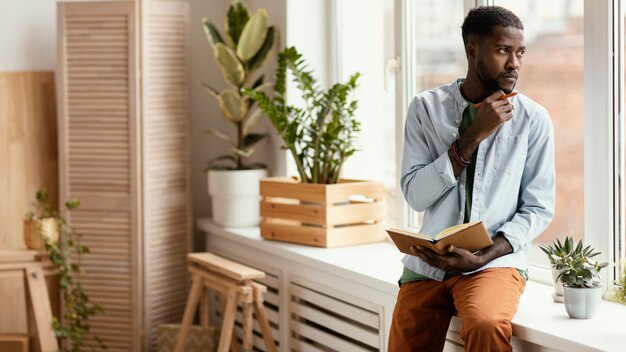 Vue de face de l'homme faisant des plans pour redécorer la maison