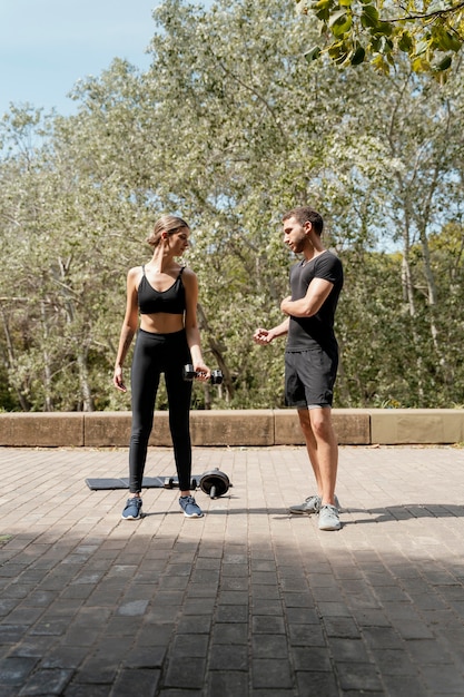 Vue de face de l'homme et de la femme à l'extérieur ensemble se préparant à faire de l'exercice