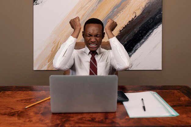 Vue de face homme frustré assis au bureau