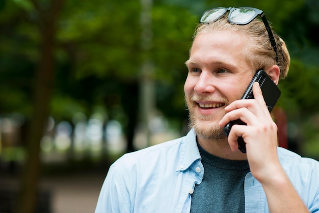 Vue de face de l'homme gai parlant au téléphone