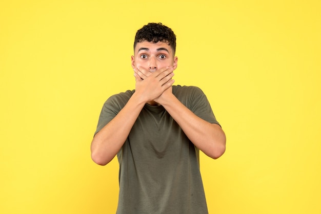 Vue de face un homme le gars choqué a couvert sa bouche avec ses bras croisés