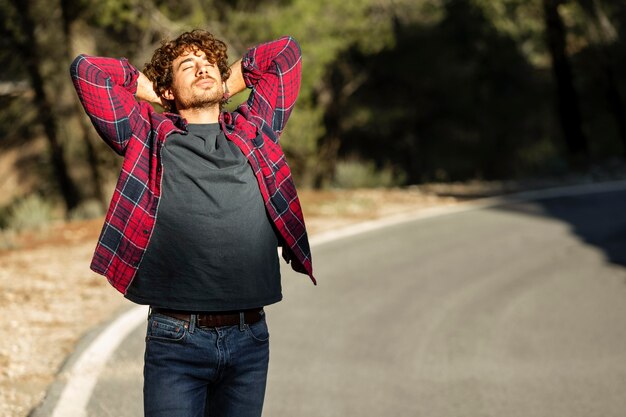 Vue de face de l'homme heureux profitant de la nature lors d'un road trip avec copie espace