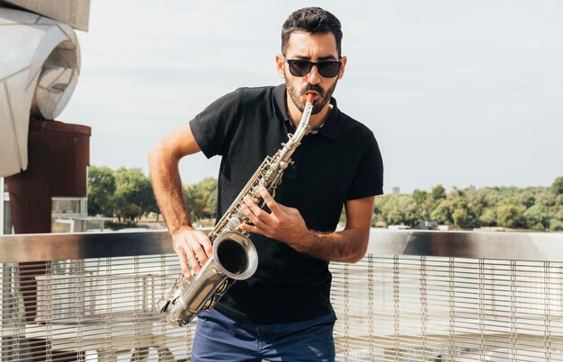 Vue de face de l'homme jouant du saxophone