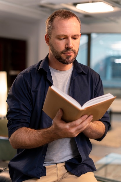 Vue de face homme lisant à l'intérieur