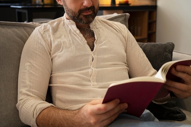 Vue de face homme lisant à la maison