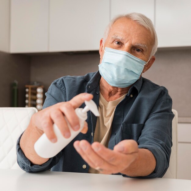 Vue de face homme avec masque et désinfectant