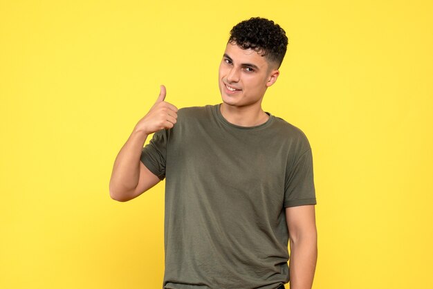 Vue de face un homme le mec souriant tient son pouce vers le haut et attend avec impatience