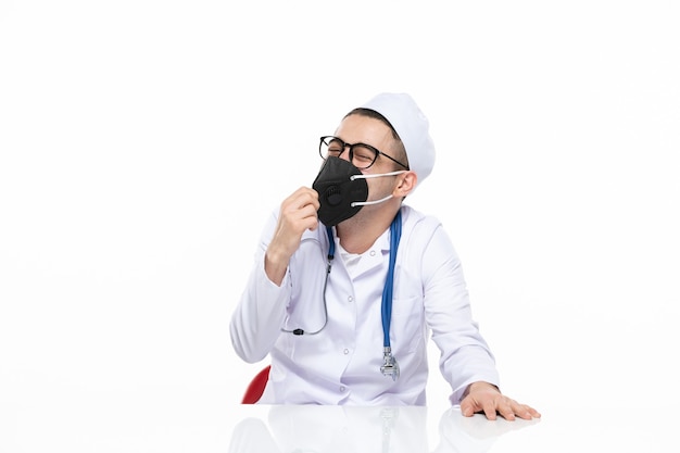 Vue de face de l'homme médecin en costume médical et masque noir spécial