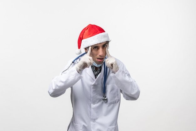 Vue de face de l'homme médecin en costume médical sur le virus mur blanc vacances covid- émotion