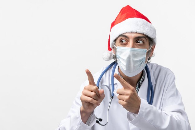 Vue de face de l'homme médecin avec masque sur fond blanc virus pandémique covid vacances