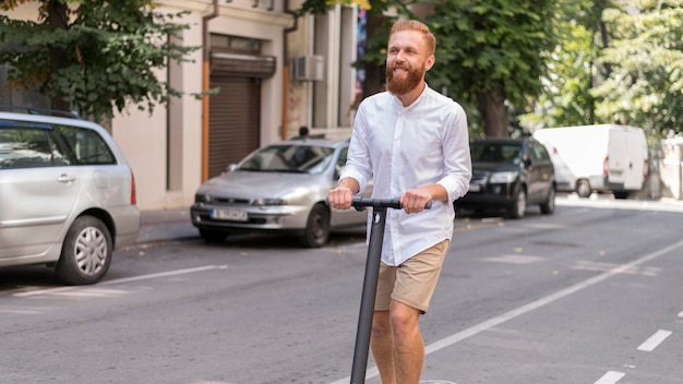 Vue de face homme moderne barbu sur scooter à l'extérieur