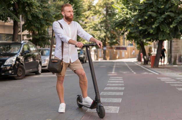 Vue de face homme moderne sur scooter à l'extérieur