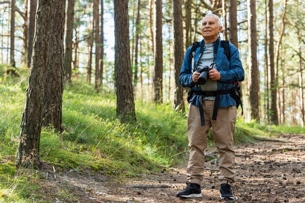 Vue de face d'un homme plus âgé, explorer la nature avec caméra