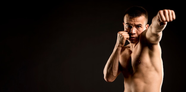 Vue de face de l'homme pratiquant la boxe avec copie espace