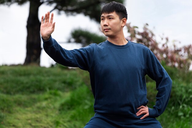 Vue de face homme pratiquant le tai chi