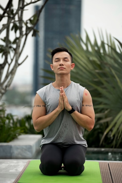 Vue de face de l'homme pratiquant le yoga