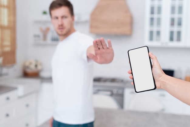 Vue de face homme refusant de tenir un téléphone